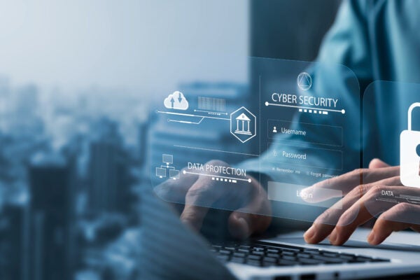 Person typing on a laptop with digital graphics displaying cybersecurity, data protection icons, and a padlock symbol overlayed on the image.